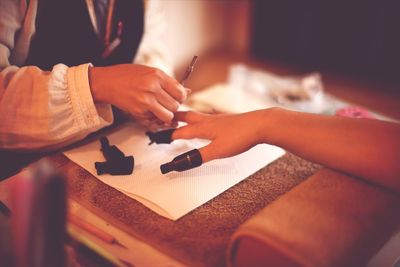 Cropped image of woman having nail manicure in spa