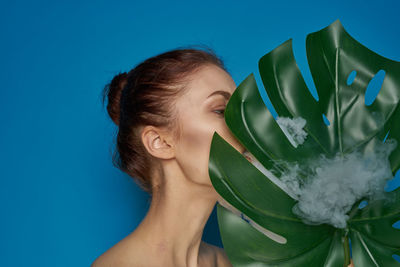 Portrait of woman against blue background