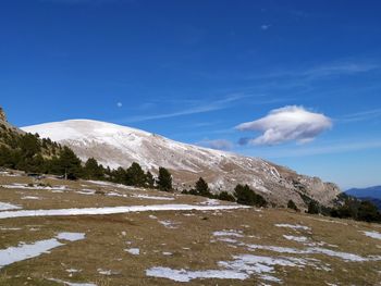 Scenic view of snowcapped mountains against blue sky