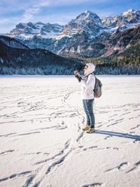 Tourists standing on snow covered mountain