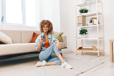 Young woman sitting on sofa at home