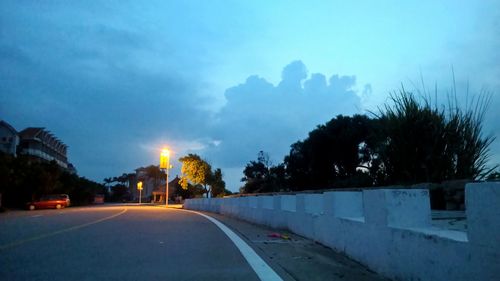 Empty road against cloudy sky