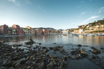 Buildings by sea against sky