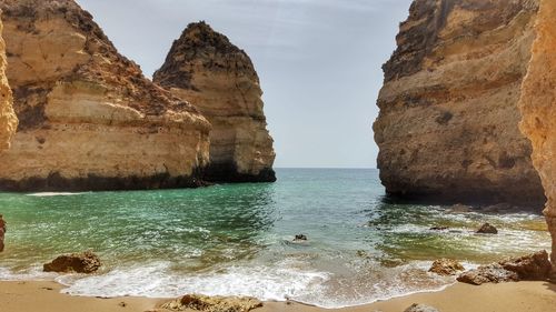 Rock formations by sea against sky