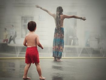 Rear view of two women standing in water