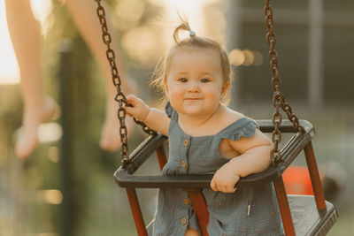 Portrait of boy swinging at playground