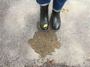 Woman mirror image with rubber boots in the puddle