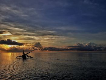 Silhouette boat in sea against sky during sunset