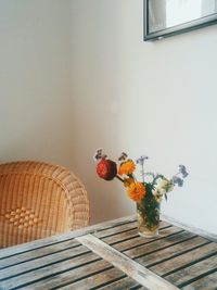 Flower vase on table against wall at home