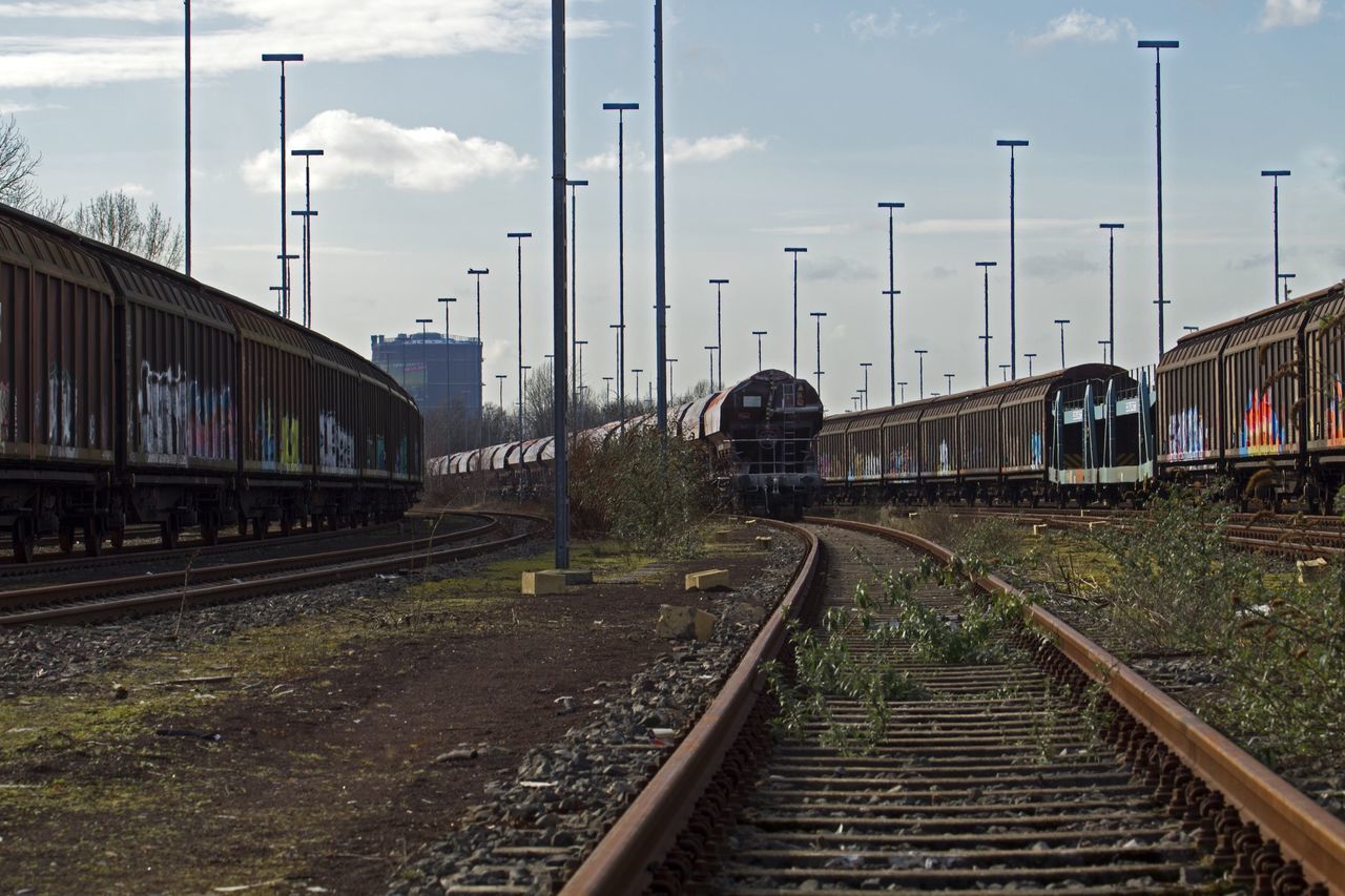 railroad track, rail transportation, transportation, public transportation, railroad station platform, railroad station, train - vehicle, sky, passenger train, train, the way forward, built structure, mode of transport, railway track, architecture, cloud - sky, diminishing perspective, travel, vanishing point, railing