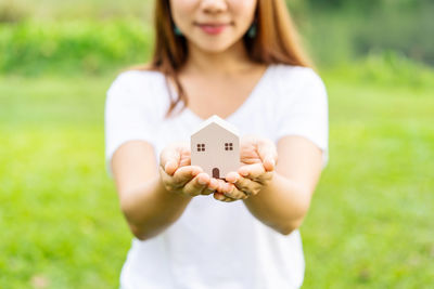 Midsection of woman holding camera on field