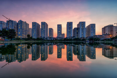 Reflection of buildings in city against sky