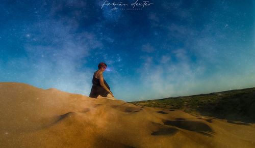 Side view of woman standing on desert against sky