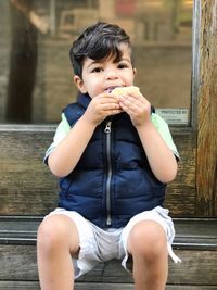 Portrait of smiling boy sitting outdoors