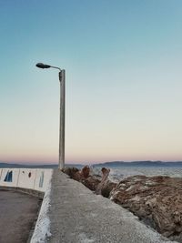 Street by sea against clear sky