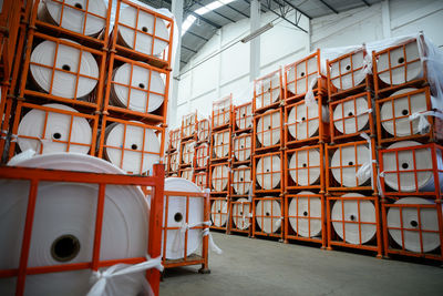 Stack of pipes on floor against wall