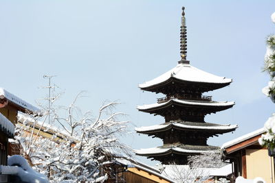 Low angle view of traditional building against sky during winter