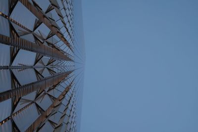 Low angle view of electricity pylon against clear blue sky