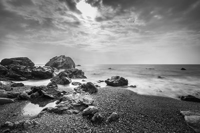 Scenic view of rocks on beach against sky