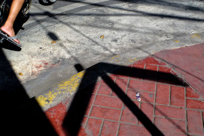 Shadow of arrow sign on footpath