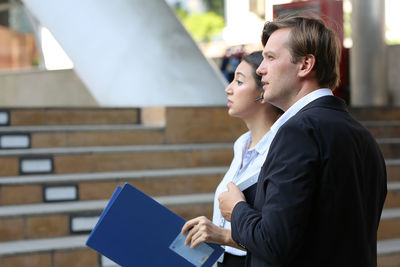 Man holding woman standing against wall