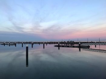 Pier over sea against sky during sunset