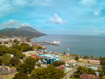 High angle view of city by sea against sky