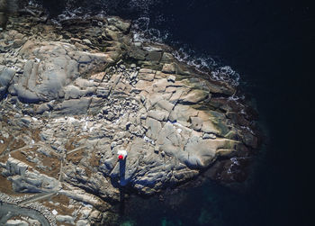 High angle view of loghthouse standing on rock