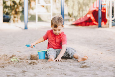 Full length of a boy playing on sand