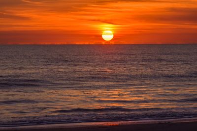 Scenic view of sea against orange sky