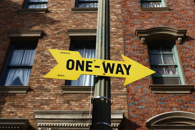 Low angle view of one way sign outside building