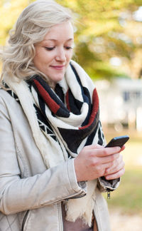 Young woman smiling while using mobile phone