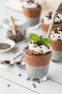 Chocolate chia pudding desserts topped with chocolate covered quinoa puffs.