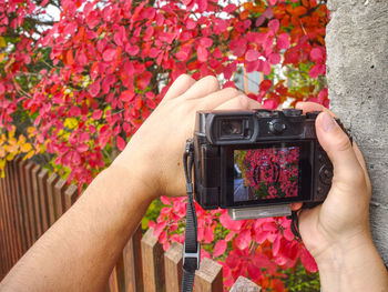 Midsection of woman photographing at camera