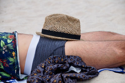 Midsection of young man relaxing at beach