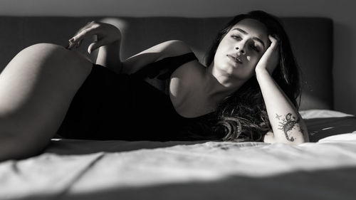 Portrait of beautiful woman lying on bed at home