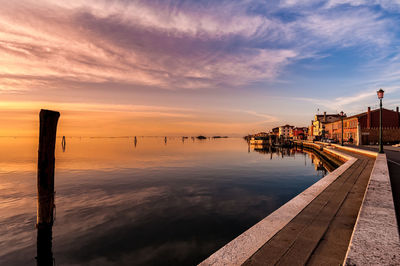 Pier over sea against sky during sunset