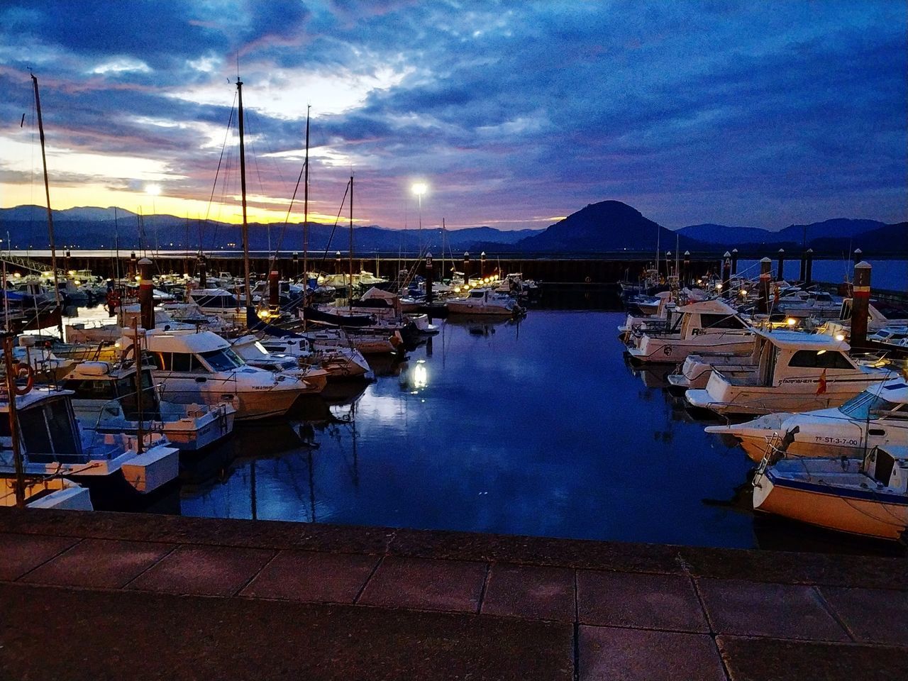 SAILBOATS MOORED AT HARBOR