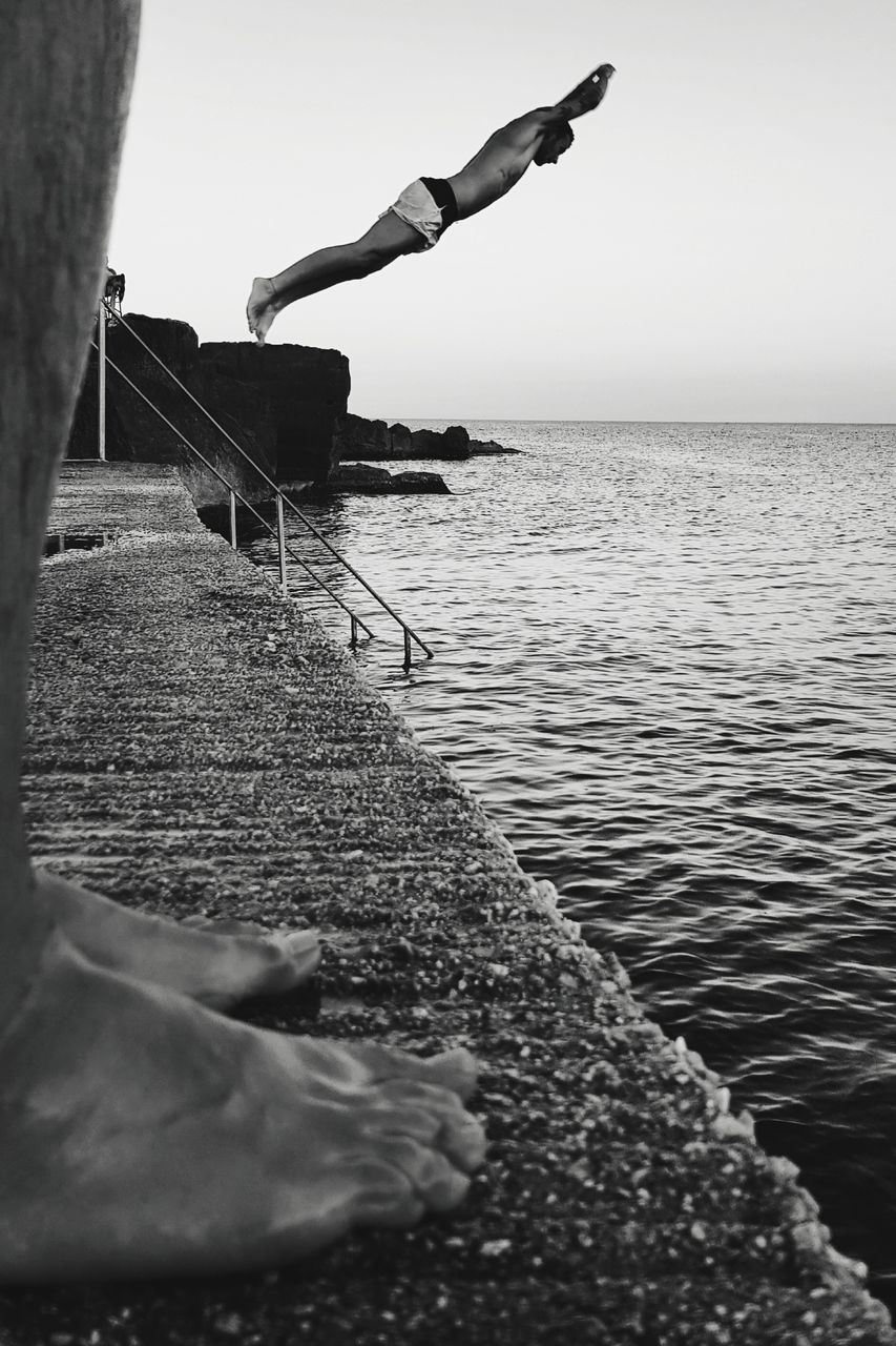 MAN SURFING ON SEA AGAINST SKY