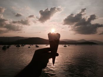 Close-up of silhouette hand holding ice cream cone