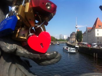 Padlocks on bridge over river in city