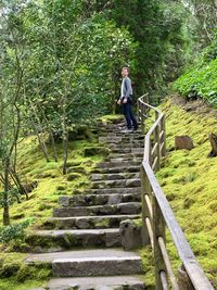 Man standing on staircase in forest