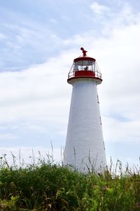 Lighthouse on field against sky