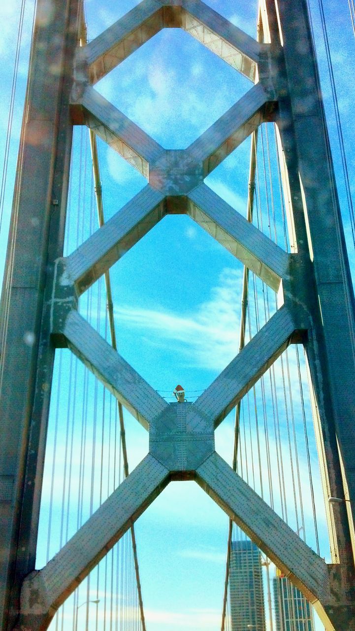 low angle view, architecture, built structure, bridge - man made structure, engineering, connection, metal, sky, blue, metallic, day, bridge, no people, outdoors, structure, architectural feature, building exterior, directly below, transportation, suspension bridge