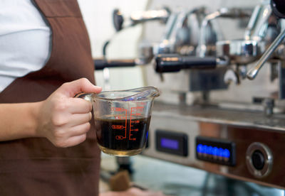 Midsection of person holding coffee cup