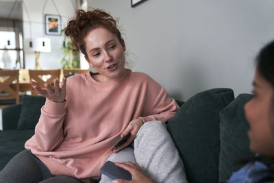 Portrait of young woman using mobile phone at home