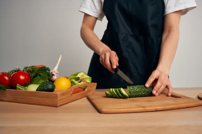 Midsection of man holding fruits and vegetables on cutting board