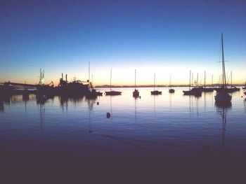 Boats in calm sea at sunset