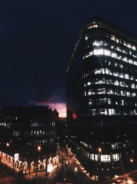 Low angle view of illuminated buildings against sky at night