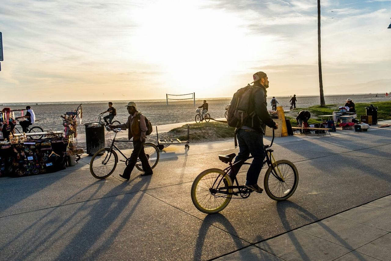 bicycle, transportation, riding, mode of transport, cycling, sky, land vehicle, sunlight, cloud - sky, real people, sunset, men, outdoors, full length, sea, day, lifestyles, women, bmx cycling, helmet, nature, biker, headwear, adult, people, adults only